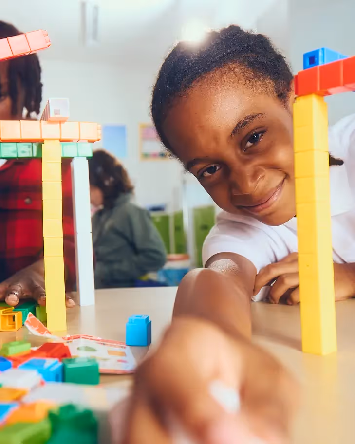A Primer student building with colorful blocks
